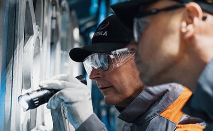 Wärtsilä employees in front of an engine