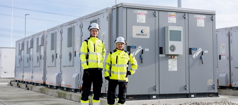 Two people stand in front of energy storage