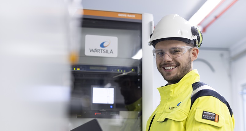 Man smiles in front of GEMS rack