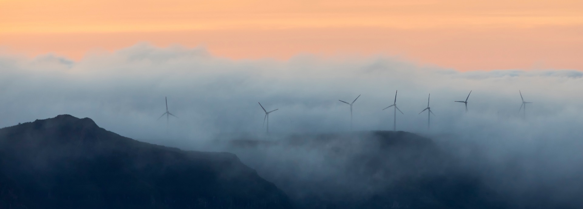 A row of wind turbines on a mountain range