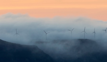 A row of wind turbines on a mountain range