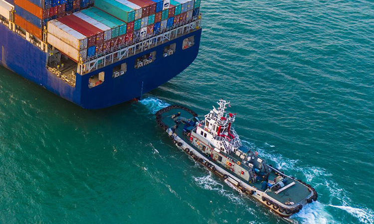 Tug boat pulls a container vessel